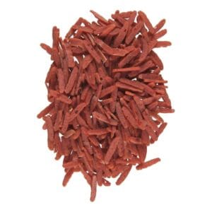 Купа червоних хрустких паличок на білому фоні.