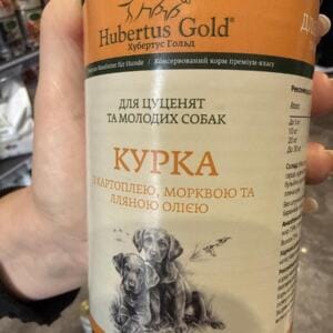 Консервований корм для собак марки Hubertus Gold з зображенням цуценят на етикетці.