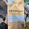 Пакет сухого корма для собак Grandorf с белой рыбой и пометкой о высоком содержании мяса и единственном злаке.