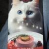 Упаковка корму для котів з зображенням білого кота та стравою з качиного паштету.