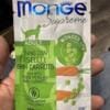 Пакетик корму для собак Monge Supreme з тунцем, зеленим горошком та морквою в руці